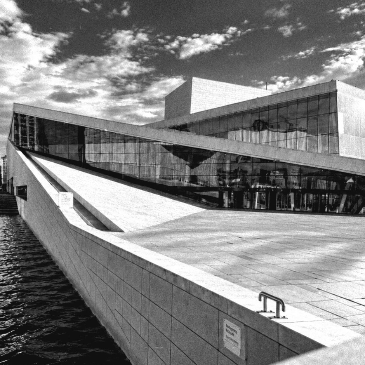 An overture in stone, glass, and sky.

#OsloOperaHouse #Oslo #ArchitectureLovers #ScandinavianDesign #BlackAndWhitePhotography